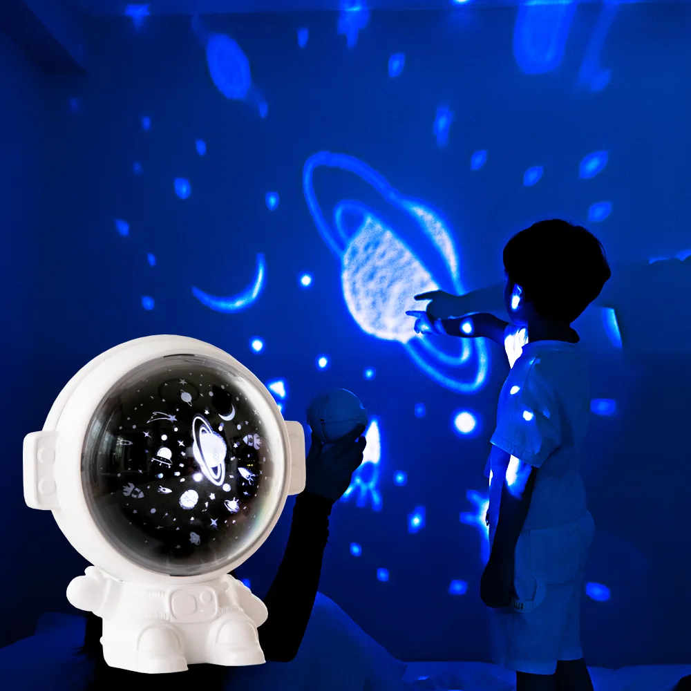 Astronaut galaxy projector filling a dark room with blue stars and planets, child pointing at the wall